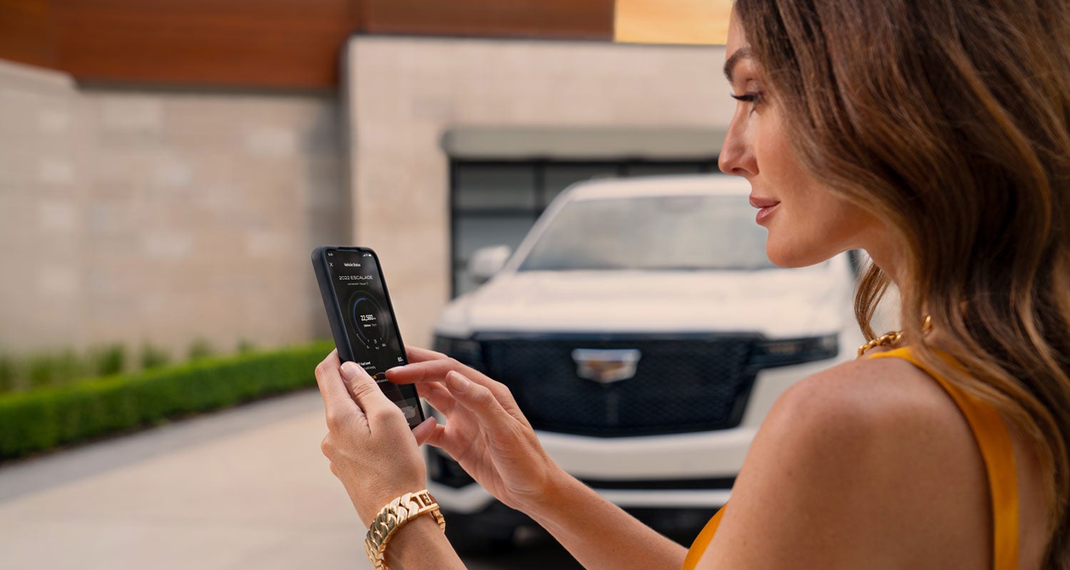 lady checking her mobile with a Cadillac vehicle background | Ed Morse Bayview Cadillac Fort Lauderdale FL in Fort Lauderdale FL