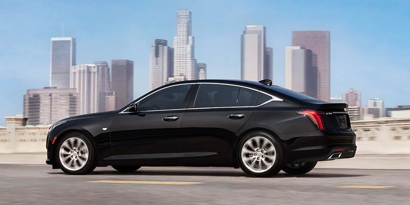 Black CADILLAC CT5 view from side with city skyline in the background